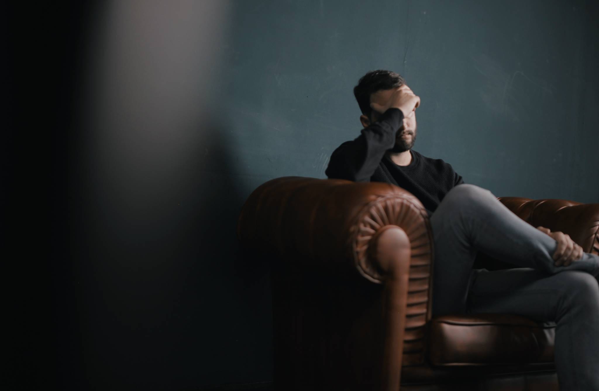 Man looking stressed sitting on a couch