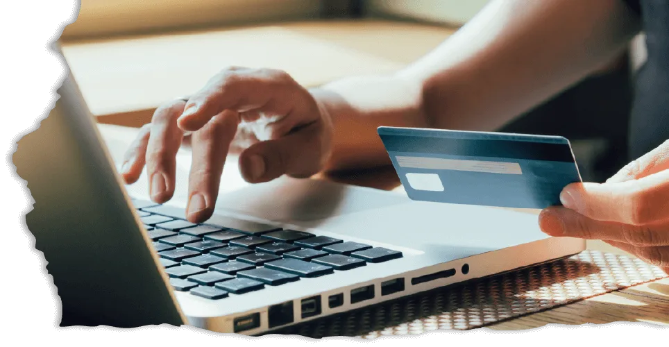 A person's hands are shown near a laptop, with one hand typing and the other holding a credit card. The scene suggests online shopping.